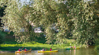 Personas navegando en kayak por un río tranquilo en Camping Seasonova Les Plages de Loire, Pays de la Loire, Francia.