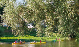 Personas navegando en kayak por un río tranquilo en Camping Seasonova Les Plages de Loire, Pays de la Loire, Francia.