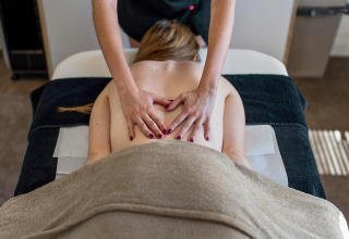 Persoon krijgt een ontspannende rugmassage bij Camping Seasonova Les Plages de Loire, Pays de la Loire, Frankrijk.