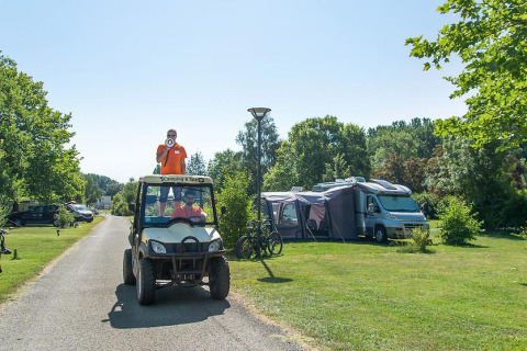 Persoon staat op een golfkar met megafoon op Camping Seasonova Les Plages de Loire, Pays de la Loire, Frankrijk.