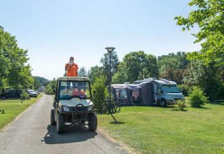 Persoon staat op een golfkar met megafoon op Camping Seasonova Les Plages de Loire, Pays de la Loire, Frankrijk.