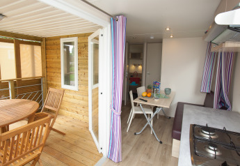 Binnen- en buitenzicht van Cottage Soleo-lodge bij Camping Seasonova Haliotis, Frankrijk, met eettafels.