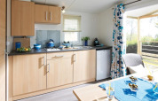 Lichte kitchenette in Cottage Zen op Camping Seasonova Haliotis in Frankrijk, met uitzicht op het terras.