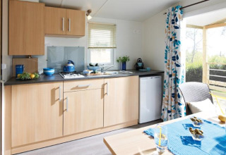 Moderne tekøkken i Cottage Zen på Camping Seasonova Haliotis i Frankrig med lys træindretning og terrasse.