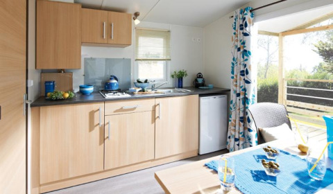 Moderne Kochnische im Cottage Zen im Camping Seasonova Haliotis, Frankreich, mit Terrasse und hellem Design.