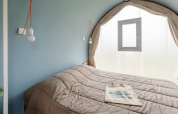 Dormitorio en una tienda safari Coco Sweet en Camping Seasonova Haliotis en Francia, con cama doble y ventana.