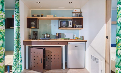 Pequeña cocina en la cabaña Corfou de Camping Seasonova Les Plages de Loire en Francia, con electrodomésticos.