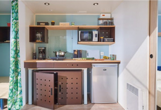 Pequeña cocina en la cabaña Corfou de Camping Seasonova Les Plages de Loire en Francia, con electrodomésticos.