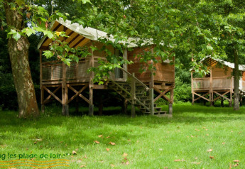 Eco-lodge hutten tussen bomen bij Camping Seasonova Les Plages de Loire in Frankrijk, zomerse sfeer.