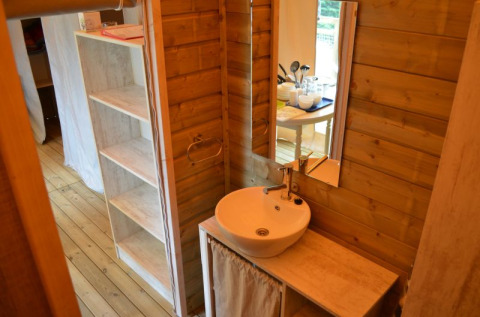 Lavabo moderno y paredes de madera en una eco-lodge en Camping Seasonova Les Plages de Loire, Francia.