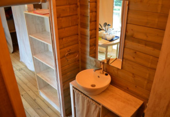 Lavabo moderno y paredes de madera en una eco-lodge en Camping Seasonova Les Plages de Loire, Francia.