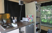 Cocina pequeña en una Bungalodge de Camping Seasonova Les Plages de Loire, Francia, con estufa y utensilios.