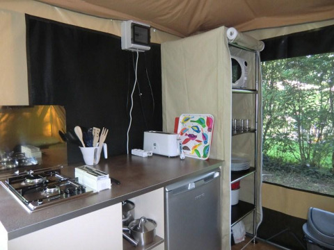 Cocina pequeña en una Bungalodge de Camping Seasonova Les Plages de Loire, Francia, con estufa y utensilios.