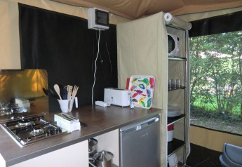 Cocina pequeña en una Bungalodge de Camping Seasonova Les Plages de Loire, Francia, con estufa y utensilios.