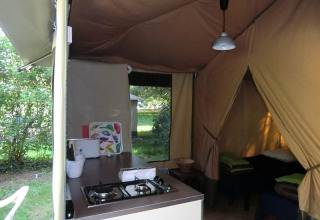 Interior de una cabaña Bungalodge con cocina y zona de dormir en Camping Seasonova Les Plages de Loire, Francia.