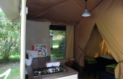 Interior de una cabaña Bungalodge con cocina y zona de dormir en Camping Seasonova Les Plages de Loire, Francia.