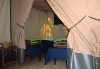 Gezellige Bungalodge met twee bedden en houten meubelen bij Camping Seasonova Les Plages de Loire, Frankrijk.