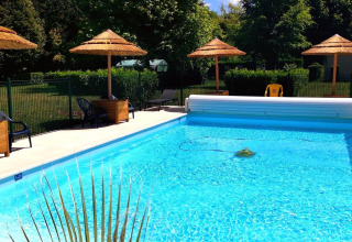 Opvarmet swimmingpool med parasoller og liggestole ved Camping Seasonova Le Martinet i Centre-Val de Loire.
