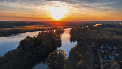 Zonsondergang boven de rivier bij Camping Seasonova Le Martinet in Centre-Val de Loire, Frankrijk, groen gebied.