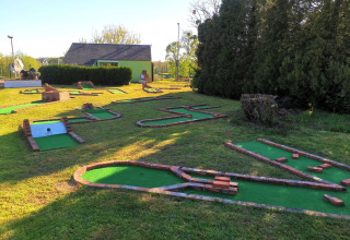 Minigolfbane ved Camping Seasonova Le Martinet i Centre-Val de Loire, Frankrig, omgivet af grønne områder.