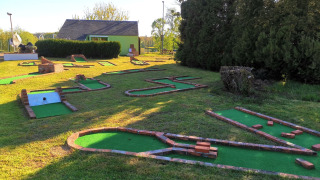 Campo de minigolf en Camping Seasonova Le Martinet en Centre-Val de Loire, Francia, rodeado de césped verde.