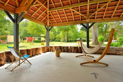 Zona exterior cubierta con hamaca y silla en Camping Seasonova Etang de la Vallée, Centro-Valle de Loira, Francia.