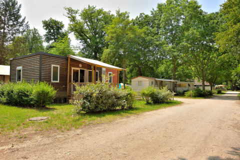 Mobil-homes de vacances dans la verdure au Camping Seasonova Étang de la Vallée, Centre-Val de Loire, France.
