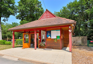 Reception building at Camping Seasonova Etang de la Vallée, surrounded by trees in Centre-Val de Loire, France.
