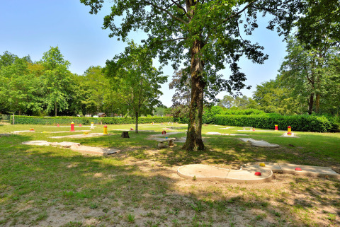 Minigolfbaan bij Camping Seasonova Etang de la Vallée, omringd door bomen in Centre-Val de Loire, Frankrijk.