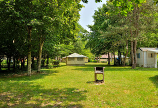 Campeggio con prato verde, tende, case mobili e barbecue all’Etang de la Vallée, Centre-Val de Loire.