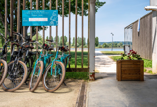 Bicycle rental area and lake view at Camping Seasonova Vesoul holiday park in Bourgogne-Franche-Comté, France.