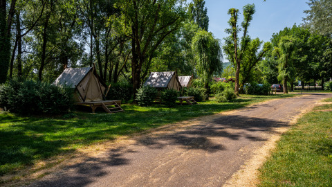 Tende allestite in una zona boscosa a Camping Seasonova Vesoul, parco vacanze in Bourgogne-Franche-Comté, Francia.
