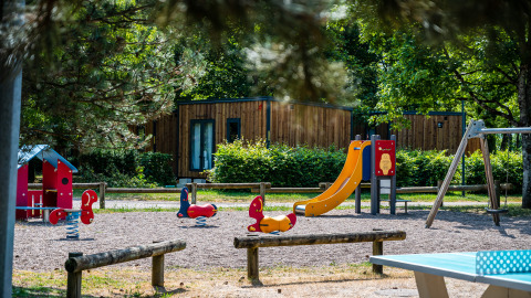 Spielplatz mit Rutsche und Schaukeln auf Camping Seasonova Vesoul im Bourgogne-Franche-Comté, Frankreich.