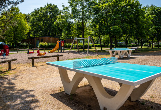 Legeplads og bordtennisbord i solen ved Camping Seasonova Vesoul, Bourgogne-Franche-Comté, Frankrig.