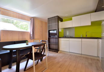 Cuisine moderne et salle à manger avec boiseries et mur vert au Cottage New Valley.