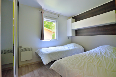 Heldere slaapkamer in Cottage New Valley met twee eenpersoonsbedden, wit linnengoed en moderne kast.