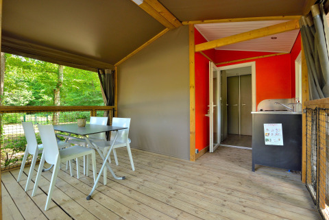 Espace repas extérieur et kitchenette d’une Mobilodge au Camping Seasonova Etang de la Vallée, France.