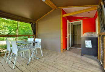 Espace repas extérieur et kitchenette d’une Mobilodge au Camping Seasonova Etang de la Vallée, France.