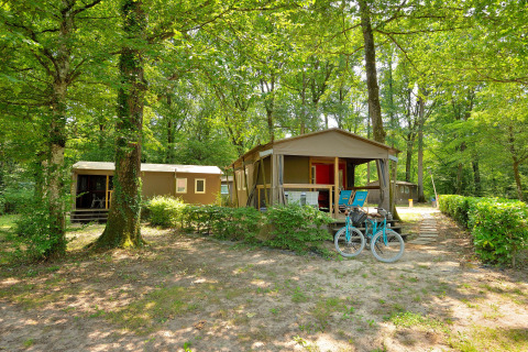 Cabañas Mobilodge en Camping Seasonova Etang de la Vallée, Francia, rodeadas de naturaleza y árboles verdes.