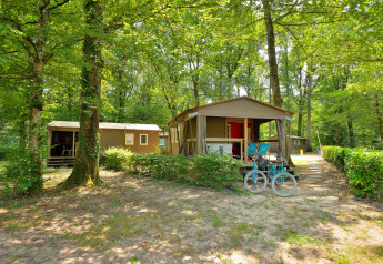 Mobilodge al Camping Seasonova Etang de la Vallée in Francia, immerse tra alberi verdi e natura rigogliosa.