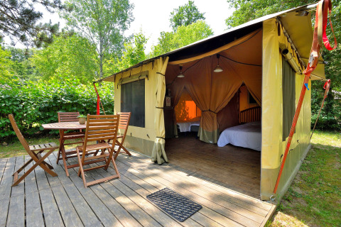 Tienda tipo safari con terraza de madera y muebles de exterior en Camping Seasonova Etang de la Vallée, Francia.