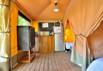 Interior de la tienda safari Lodge Nature en Camping Seasonova Etang de la Vallée con cocina y suelo de madera.
