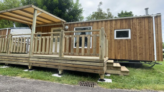 Foto van Cottage Zen, een houten chalet met terras en overkapping in een rustige natuurlijke omgeving.