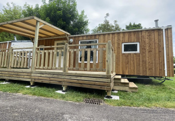 Foto van Cottage Zen, een houten chalet met terras en overkapping in een rustige natuurlijke omgeving.