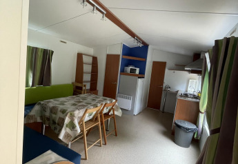 Binnenzicht van het knusse huisje Cottage Zen bij Camping Seasonova Vesoul in Frankrijk met eethoek.