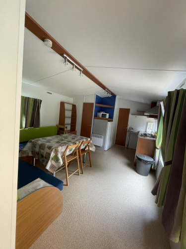 Vista interior de una acogedora cabaña, Cottage Zen, en Camping Seasonova Vesoul en Francia con comedor visible.