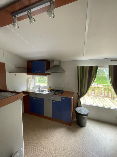 Küche in der Hütte Cottage Zen auf Camping Seasonova Vesoul in Frankreich mit Blick auf die Terrasse.