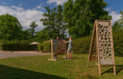 Two people play a large outdoor board game on the grass at Camping Seasonova Vittel holiday park in France.