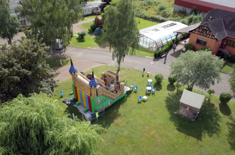 Vista aerea di un castello gonfiabile e aree verdi al Camping Seasonova Les Portes d'Alsace, Grand Est, Francia.