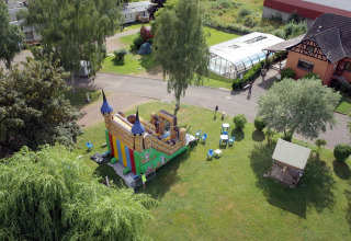 Luchtfoto van een springkasteel en grasveld op Camping Seasonova Les Portes d'Alsace, Grand Est, Frankrijk.